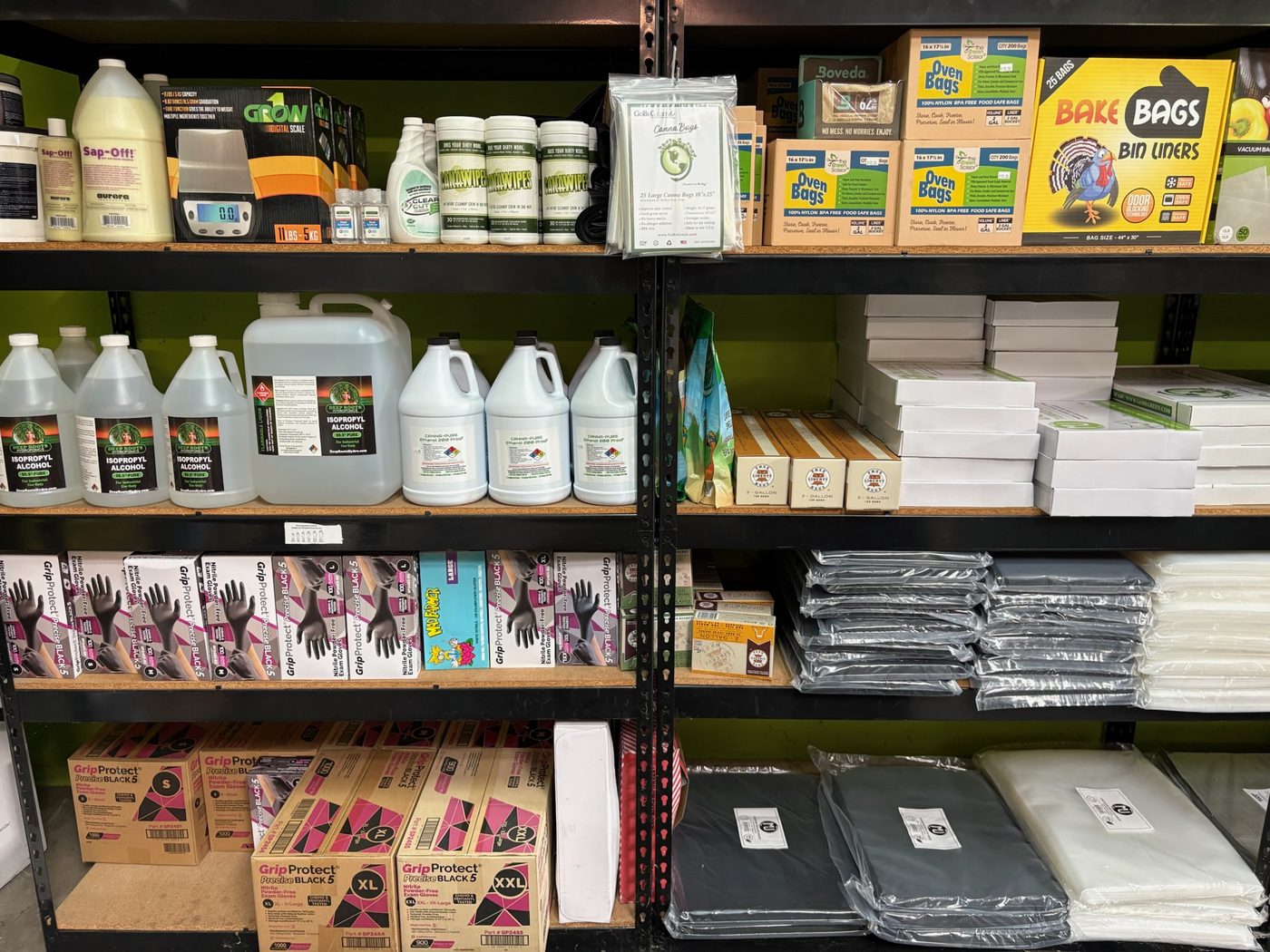 Harvest and packaging supplies shelf with scales, gloves, storage bags, and Deep Roots isopropyl alcohol